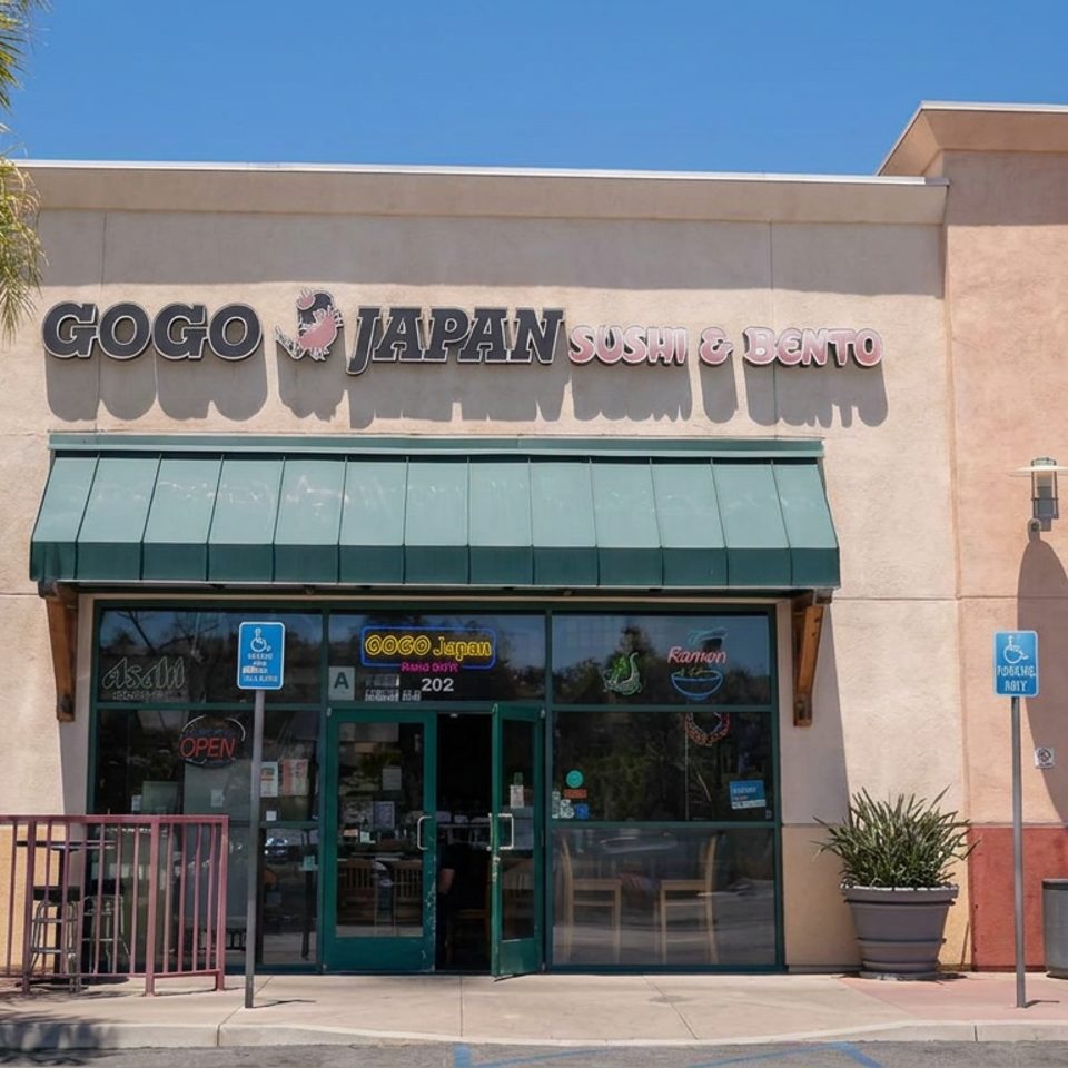Sunny strip-mall storefront for GoGo Japan Sushi & Bento beside a Thai restaurant, with palm trees, awnings, and accessible parking.